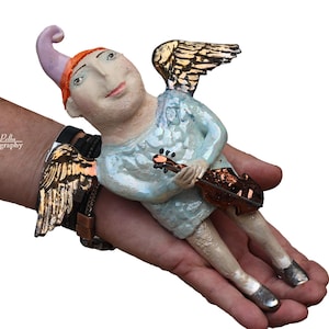 Angelic dream of flying and music -this is a ceramic wall sculpture that is part of the &quot;Parallel World&quot; collection by Dorota Urbaniak-Pelka