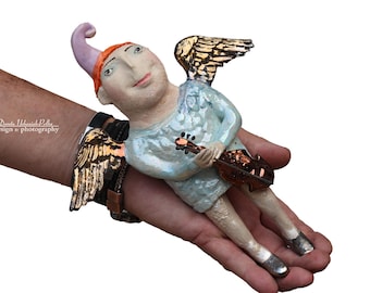 Angelic dream of flying and music -this is a ceramic wall sculpture that is part of the &quot;Parallel World&quot; collection by Dorota Urbaniak-Pelka