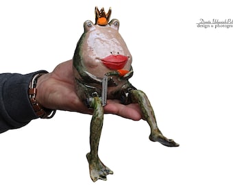 Kiss his carmine lips - appreciate his elegant orange opera hat - a green frog with moving legs -  sculpture from the "Parallel world"