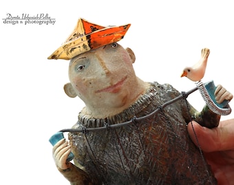 A theatrical manipulator in a golden cap according to "Parallel World" - a wall sculpture , ceramic sculpture