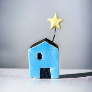 Miniature light blue house with star