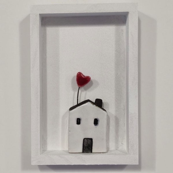 Photo maison blanche avec coeur en céramique.