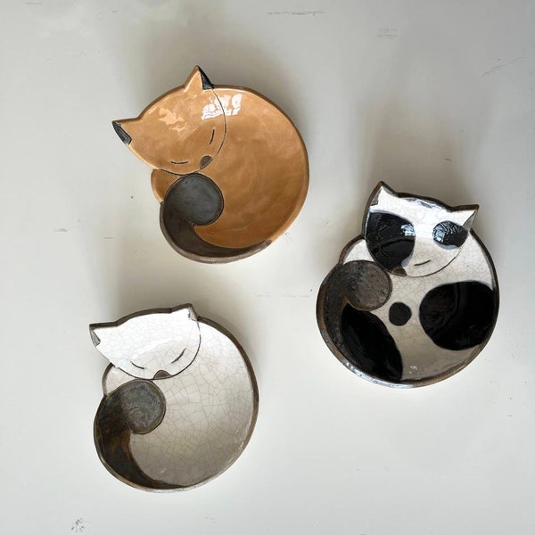 Keramikschale in Katzenform. Weiße Ringhalterplatte. Schlafende weiße Katze