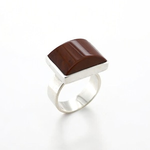 May include: A silver ring with a rectangular brown stone set in a silver band.