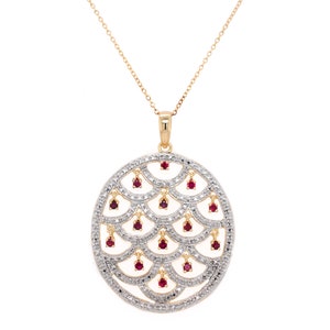Op de afbeelding: Een gouden ketting met een hanger in een cirkelvormig ontwerp met een delicaat, ingewikkeld patroon van kleine diamanten en rode robijnen.