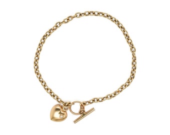 May include: A gold chain bracelet with a heart-shaped charm and a t-bar clasp.