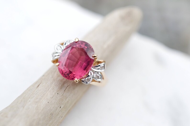 May include: A pink oval gemstone ring with a gold band and diamond accents.