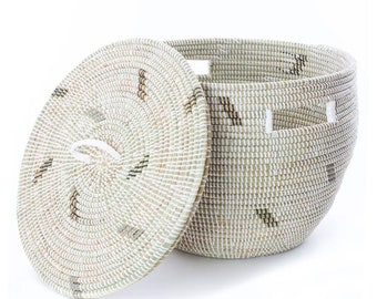 May include: A white and brown woven storage basket with a lid. The basket has a white handle on the lid and white accents on the sides.