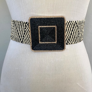 Black and white raffia belt with a square black buckle with gold details.  Black and white women’s summer raffia belt.