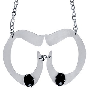May include: A silver necklace with two black stones and a unique, abstract design.