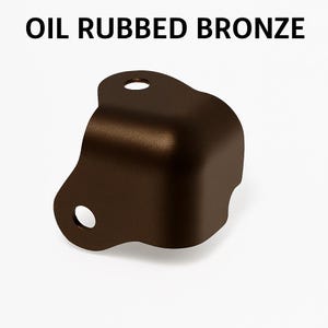 May include: Oil rubbed bronze corner bracket with two mounting holes. The bracket is a dark brown color and has a rounded corner. The text "OIL RUBBED BRONZE" is displayed above the bracket.