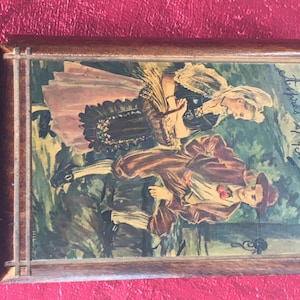 May include: A wooden box with a vintage illustration of a couple in traditional clothing. The box has a label that reads "Stippes of Buchs".