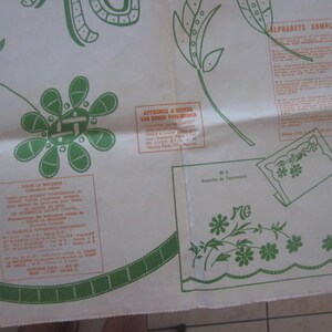 May include: A white sheet of paper with a green and white floral design. The paper has instructions for embroidery, including a section titled "Alphabets Complet." The paper also has a section titled "Apprenez a broder vos motifs" with instructions in French.
