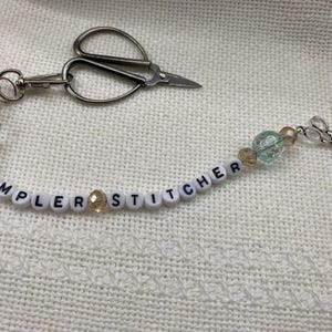 Sampler Stitcher”  scissor fob with bead accents, scissor & heart charms. Scissors not included.