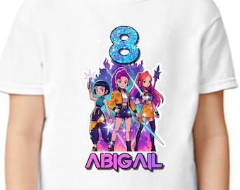 May include: White t-shirt featuring a colorful graphic of three anime-style girls, the number 8, and the name "ABIGAIL" in purple. The design has a vibrant, glittery effect, perfect for a birthday celebration.