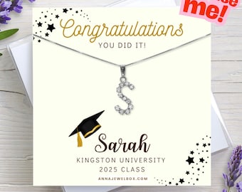 May include: A silver necklace with a sparkling letter "S" pendant, displayed on a congratulatory card. The card reads "Congratulations, You Did It!" and includes a graduation cap graphic, the name "Sarah", and "Kingston University 2025 Class".