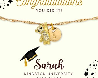 May include: A gold-toned bracelet with a teddy bear charm and a circular charm with the letter "S". The image includes the text "Congratulations, You Did It!" and "Sarah, Kingston University, 2025 Class". A graduation cap is also featured.