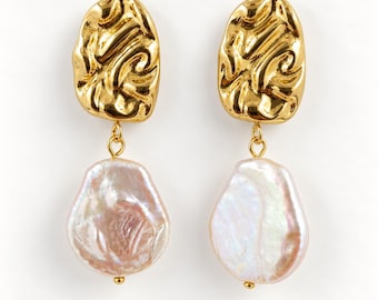 May include: A pair of drop earrings featuring a textured, organic-shaped gold-tone metal stud at the top, connected by a small jump ring to a large, irregular, iridescent white and pale pink baroque pearl pendant at the bottom.