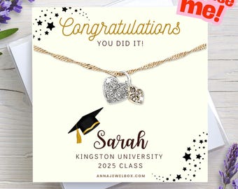 May include: A gold-toned necklace with two heart-shaped pendants, one encrusted with crystals. The necklace is displayed on a graduation card with the text "Congratulations, You Did It!" and personalized with a name, university, and class year.