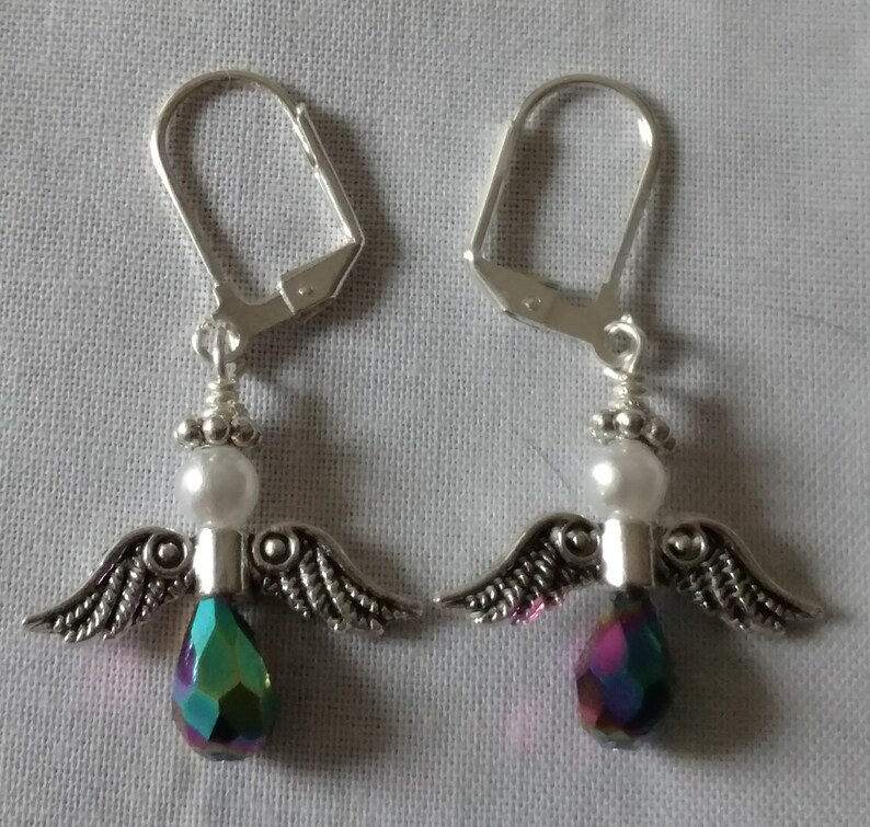 May include: A pair of silver angel wing earrings with iridescent teardrop crystals and white pearl beads.