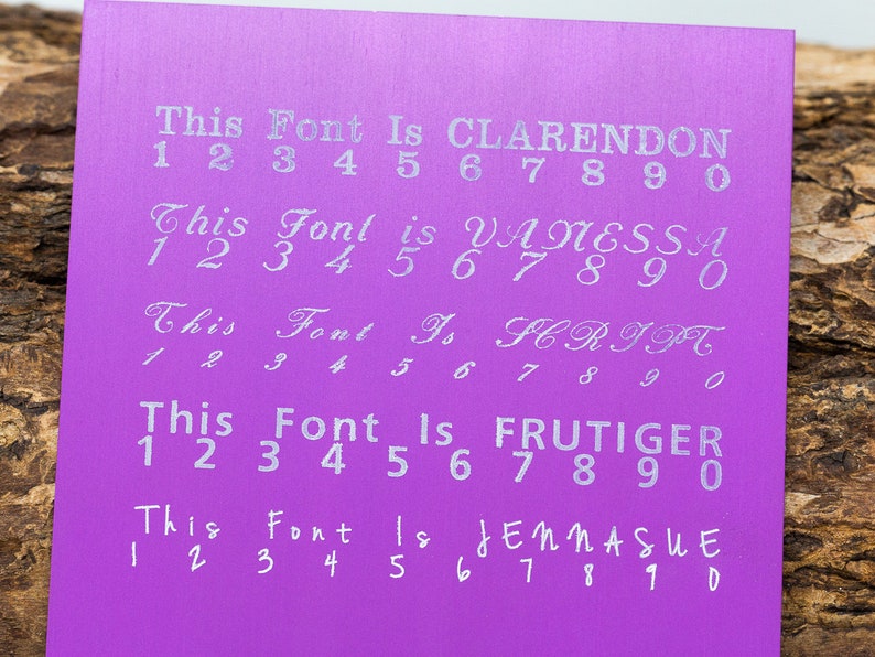 May include: A purple card with five different fonts displayed. Each font is labeled with its name and includes the numbers 1 through 9 and 0. The fonts are Clarendon, Vanessa, Script, Frutiger, and Jennasue.
