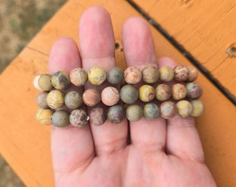 May include: A multi-strand bracelet made of brown, yellow, and green jasper beads.