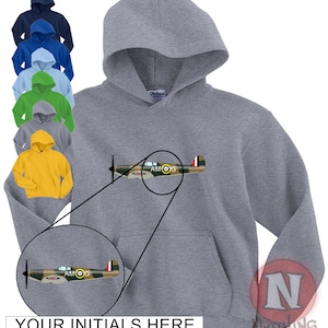 Könnte beinhalten: Ein grauer Kapuzenpullover mit einem kleinen gestickten Bild eines Tarnflugzeugs mit den Buchstaben "AMOG" an der Seite. Der Pullover hat eine große Tasche auf der Vorderseite und eine Kapuze mit Kordelzug.