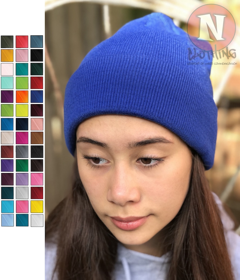 May include: A royal blue beanie made of knitted fabric. The beanie is worn by a person with long brown hair.