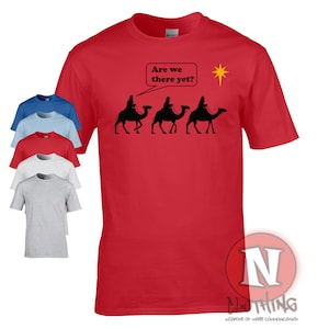 May include: Red t-shirt with a black silhouette of three wise men riding camels and the text "Are we there yet?" with a yellow star above them.