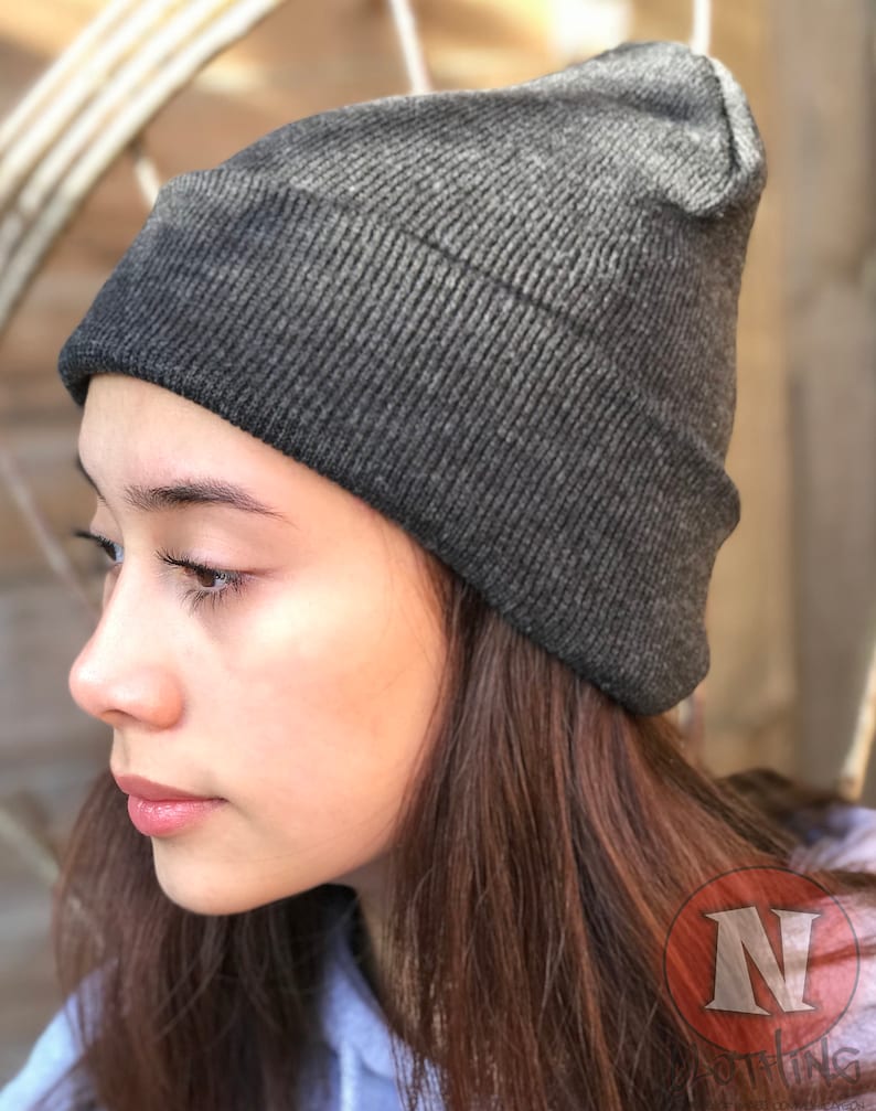 May include: A dark gray beanie with a ribbed texture. The beanie is made of a soft, comfortable material.