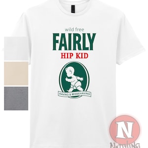 Puede incluir: Camiseta blanca con un gráfico verde y rojo que dice "wild free FAIRLY HIP KID RAVING & MISBEHAVING".