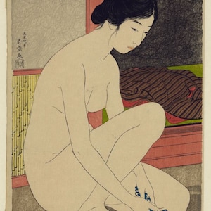 May include: A Japanese woodblock print depicting a person with dark hair styled in an updo, kneeling while washing with a blue cloth in a red basin. The scene includes a yellow bamboo-patterned screen, a dark textured area, and Japanese text.