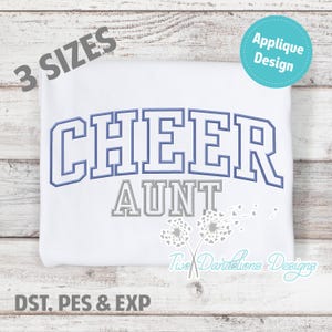 May include: White t-shirt with a blue and gray applique design that says "Cheer Aunt" with two gray dandelions with white seeds. The text "3 Sizes" is in the top left corner and "Applique Design" is in the top right corner. The text "DST, PES & EXP" is in the bottom left corner.