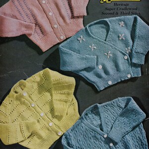 Peut inclure: Quatre cardigans en tricot pour bébé dans différentes couleurs et motifs. Les cardigans sont disposés sur un fond sombre. Le texte sur l'image indique "Marriners Heritage Super Cradlewool Second & Third Sizes."