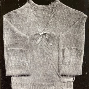 May include: A gray knitted cardigan with a wrap front and a bow tie closure. The cardigan has long sleeves and pockets on the sides.