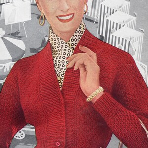 May include: A red knitted cardigan with a white and black polka dot blouse underneath. The cardigan has a V-neck and three buttons down the front. The woman in the image is wearing a black skirt and holding a bouquet of flowers.
