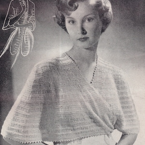 May include: A woman wearing a white crocheted top with a V-neckline. The top has a delicate, lacy pattern and short sleeves. She is holding a small, white saucer with a cup in her hand.