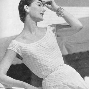 May include: A white crocheted top with a scoop neckline and short sleeves. The top is fitted and has a delicate, openwork design.