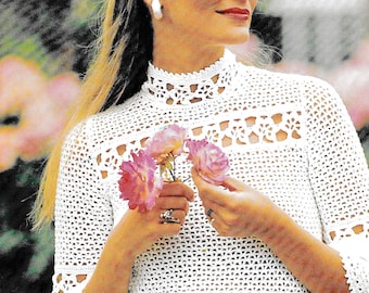 Pode incluir: Top branco de crochê com gola alta e um delicado padrão floral. O top tem mangas 3/4 e uma borda de crochê ao redor do pescoço e da bainha.