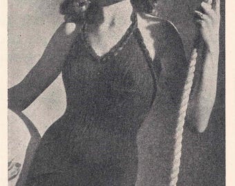 Pode incluir: Um maiô preto com decote halter e um detalhe de corda. O maiô está sendo usado por uma mulher com cabelo ondulado e um sorriso.