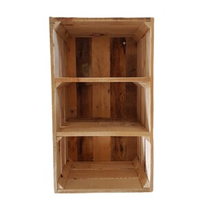 May include: A wooden shelving unit with three compartments, constructed from reclaimed wood. The unit displays a variety of natural wood tones. Ideal for storage or display, it adds a rustic charm to any room. The unit measures approximately 60cm in height.