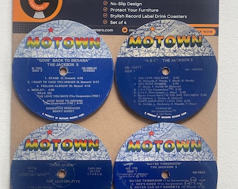 May include: Set of four blue and white vinyl record coasters featuring album covers from The Jackson 5. Each coaster has a different album title: "Goin' Back to Indiana", "ABC", "Third Album", and "Maybe Tomorrow".