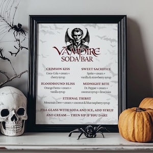 May include: A framed "Vampire Soda Bar" sign with a vampire illustration, drink recipes, and Halloween decor. The sign is in a black frame, with pumpkins, skulls, and a spider adding to the spooky theme.