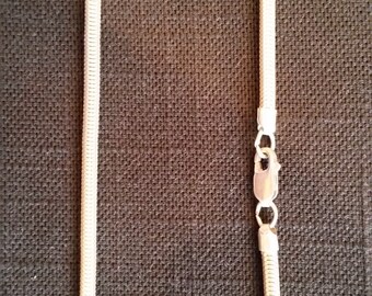 May include: A silver snake chain necklace with a lobster clasp closure.