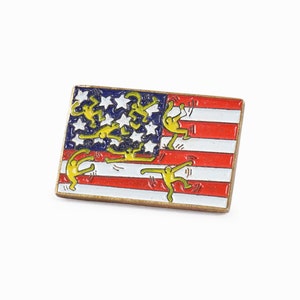 Könnte beinhalten: Eine goldfarbene Anstecknadel mit einem rot-weiß-blauen amerikanischen Flaggenmuster. Gelbe Strichmännchen sind dargestellt, die die Flagge erklimmen.