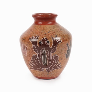 May include: A small, brown ceramic vase with a speckled glaze. The vase is decorated with a black and brown frog design.