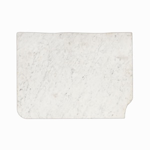 May include: A rectangular, white marble cutting board with a slightly irregular edge and a small notch cut out of one corner. The marble has subtle gray veining throughout, giving it a natural, textured appearance. The board is set against a plain white background.