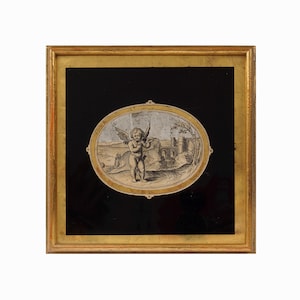 May include: A square framed artwork featuring a central oval illustration of a winged cherub standing in a landscape with a distant building. The illustration is set against a black background within a gold-toned frame with a metallic finish.