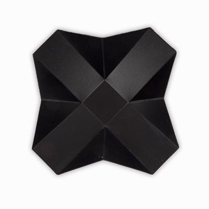 May include: A black origami star with a folded design. The star is made of a thick, textured paper.