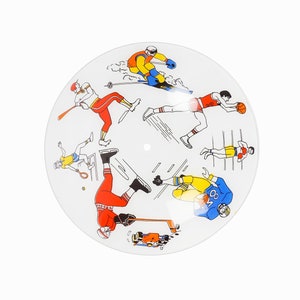 May include: A white round ceiling light fixture with a colorful design of athletes playing different sports. The athletes are depicted in a cartoon style and include a skier, a baseball player, a basketball player, a tennis player, a hockey player, and a football player.
